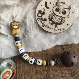 Attache tétine personnalisée lion en silicone avec perles silicone dans des tons marron, beige et moutarde, personnalisable avec le prénom de bébé – Babybou-Créa.