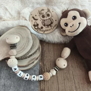 Attache doudou personnalisée en bois et silicone avec deux clips en bois, perles au crochet écrues et prénom personnalisé.